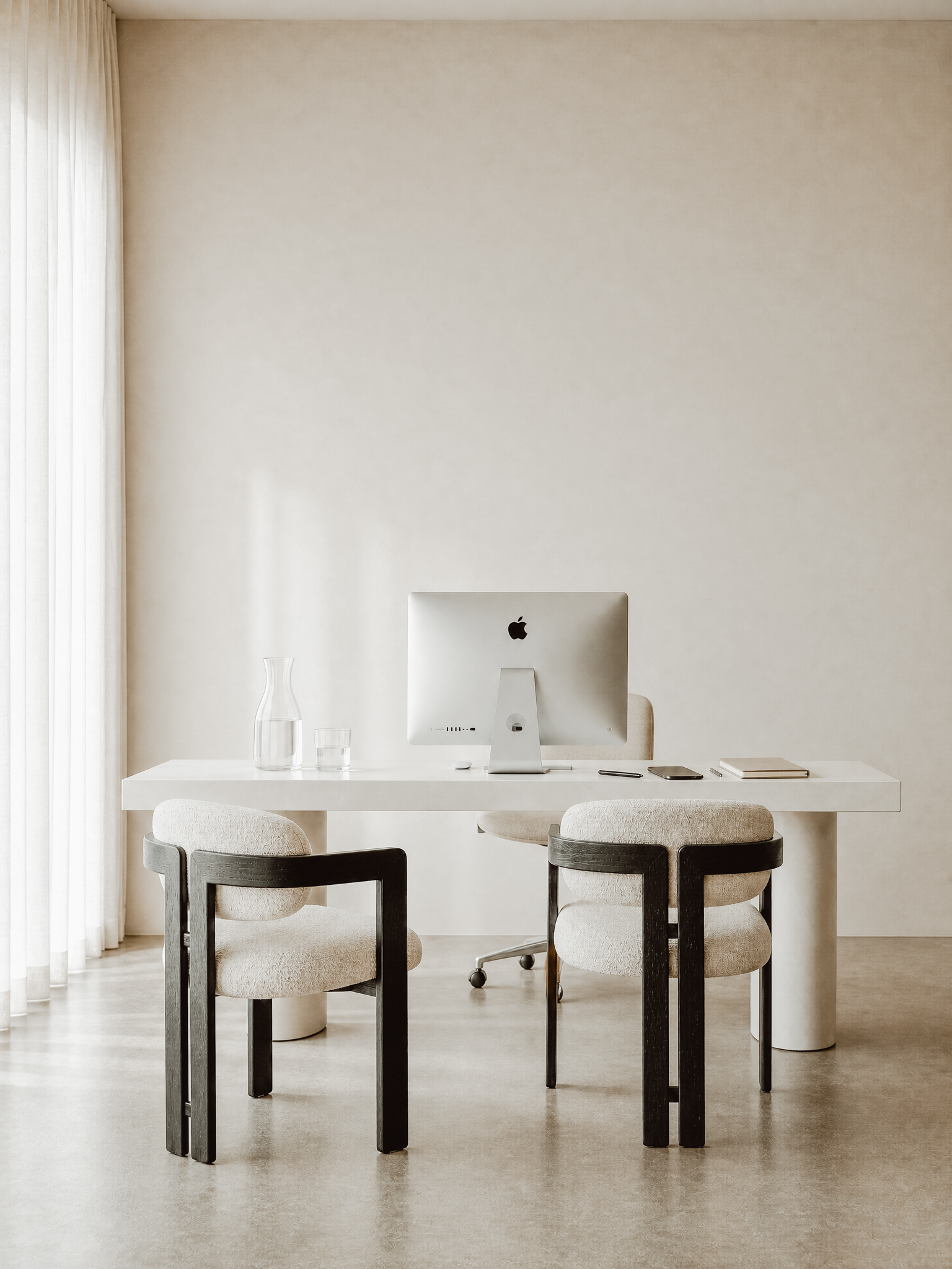 A calm, minimalist consultation room with sculptural furniture, the kind of space aesthetic practices use to meet new patients